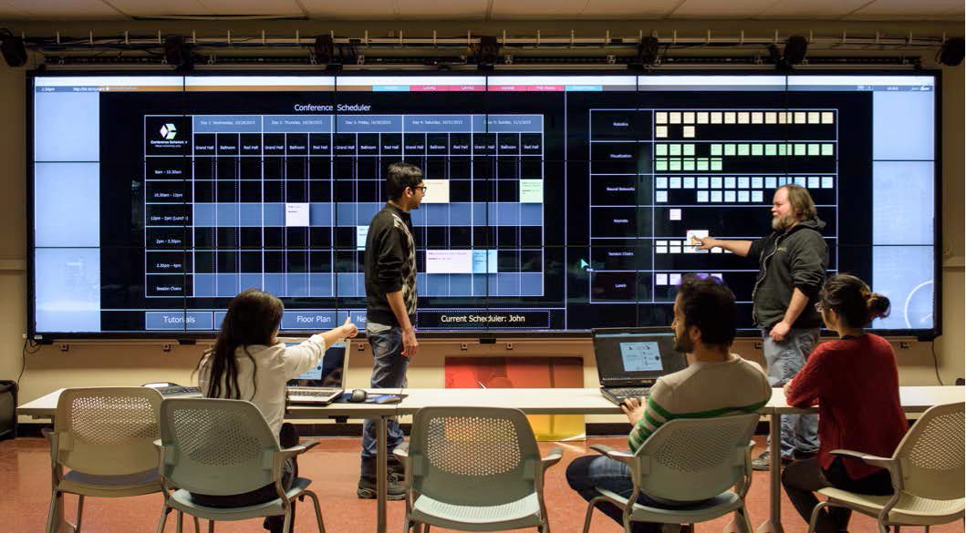 Simulated organization committee scheduling a conference using StickySchedule. Interaction is supported from both personal devices (e.g. a mouse from one’s laptop) and touch directly on the large-scale shared display