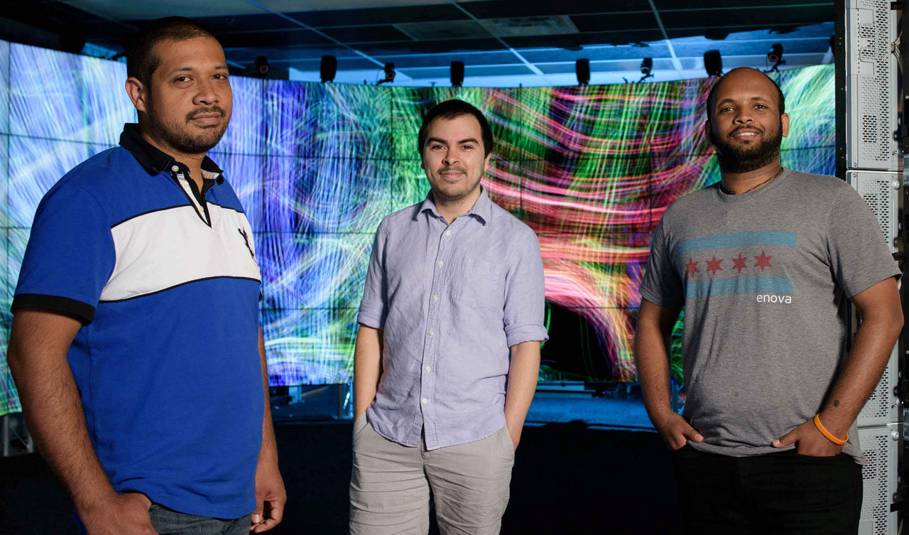 UIC Computer Science undergraduates (left to right) Carlos Uribe, Josh Rodriguez and Brook Habtegiorgis in the CAVE2™ Hybrid Reality Environment developed by the UIC Electronic Visualization Laboratory (EVL).